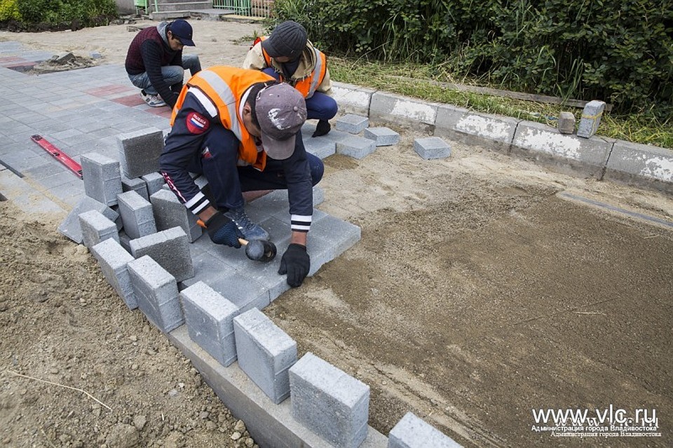 Рабочие кладут новую брусчатку на тротуаре. Фото: vlc.ru
