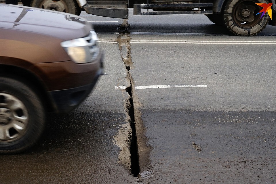 Через щель в асфальте видна конструкция моста