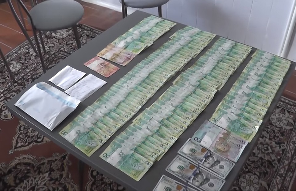 Врача задержали с поличным после очередной взятки. Фото: кадр оперативной съемки МВД.