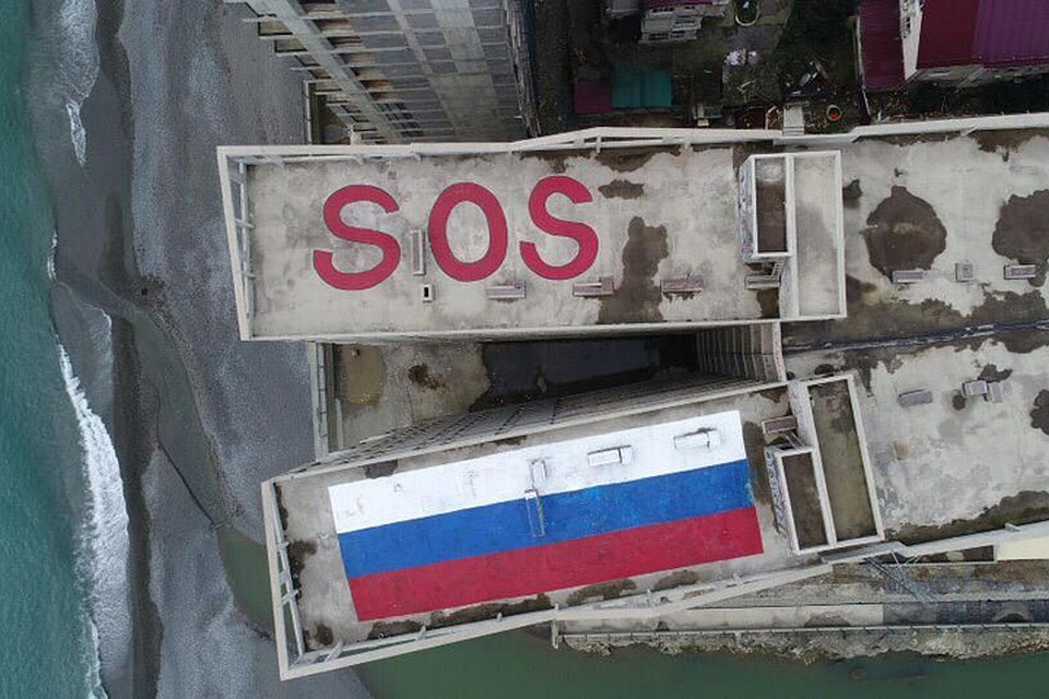 На крышах высоток появился 30-метровый международный сигнал бедствия SOS и 50-метровый флаг России Фото: кадр с видео