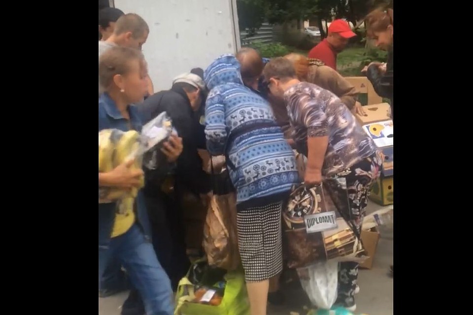 Хорошо одетые люди выбирают еду среди выброшенных продуктов. Фото: facebook.com