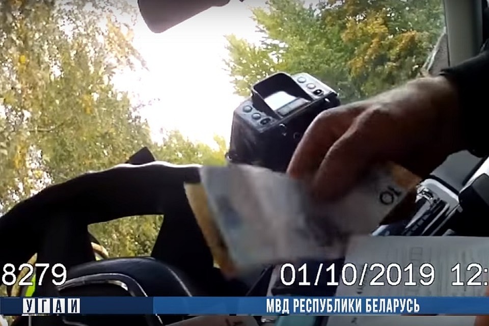 Фигурант положил деньги на планшет, и сотрудник ГАИ позвонил дежурному. Фото: стоп-кадр.