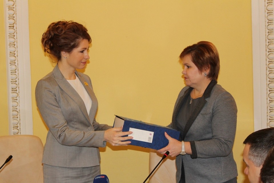 Глава администрации Елена Сорокина (справа) передает проект бюджета Юлии Рокотянской (слева). Фото: rgdrzn.ru