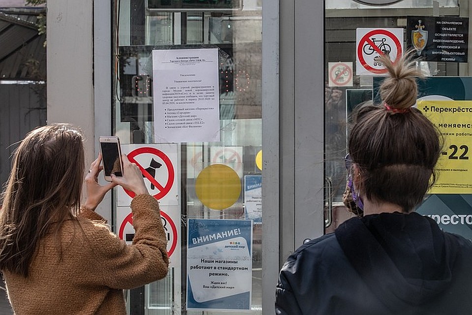 Посетители ТК фотографируют объявление в котором говорится про указ мэра Москвы о приостановке работы сферы услуг. Фото: Андрей АБРАМОВ