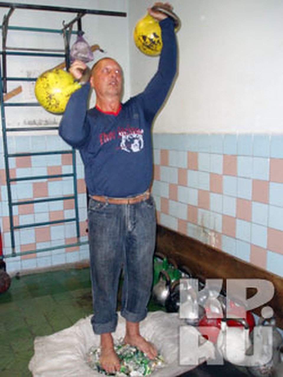 Сергей начинает свой смертельный номер с гирями и спокойно топчется босыми ступнями по стеклу. Фото: Лариса МАКСИМЕНКО