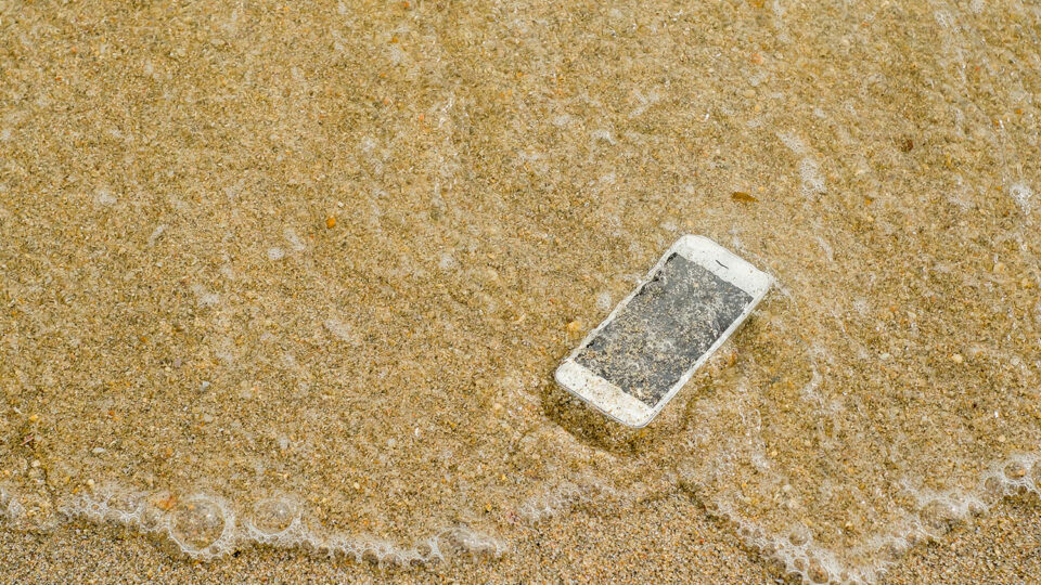 Телефон упал в воду. Фото: Nitiphonphat / Shutterstock / Fotodom