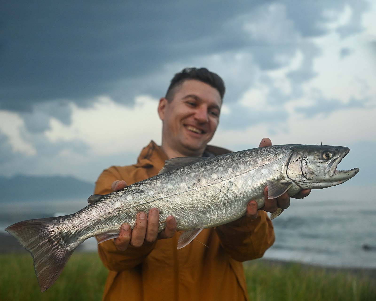 Мужчина держит пойманную рыбу