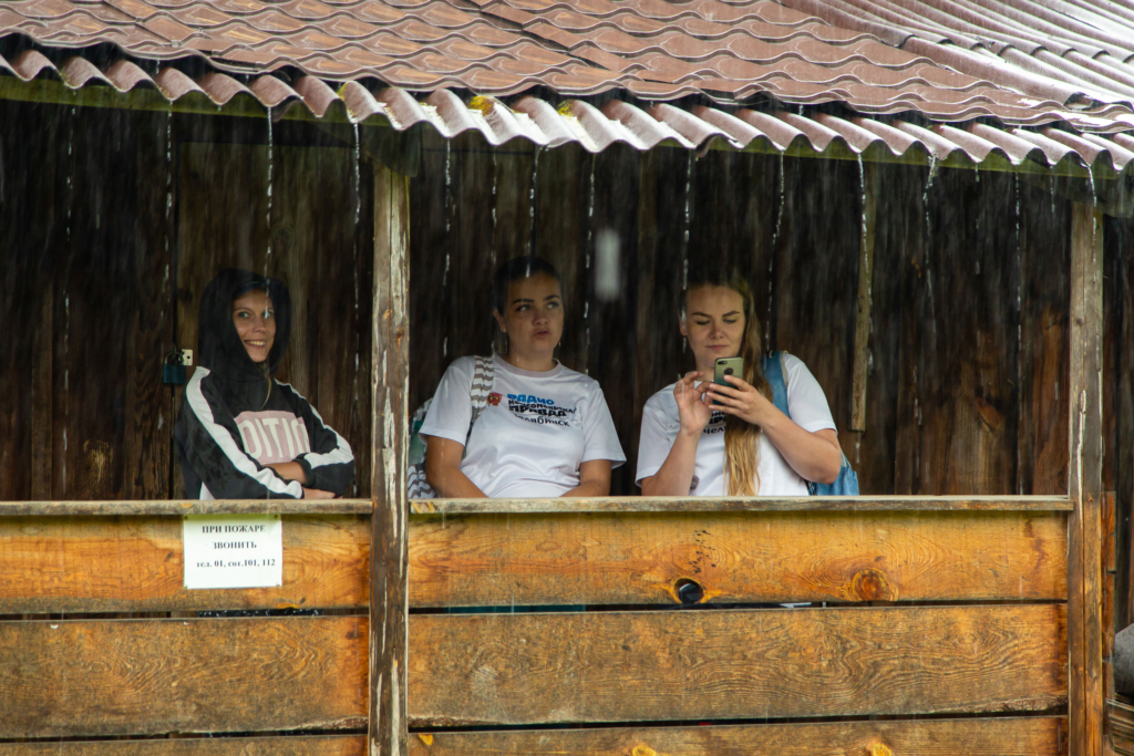 люди прячутся от дождя на веранде