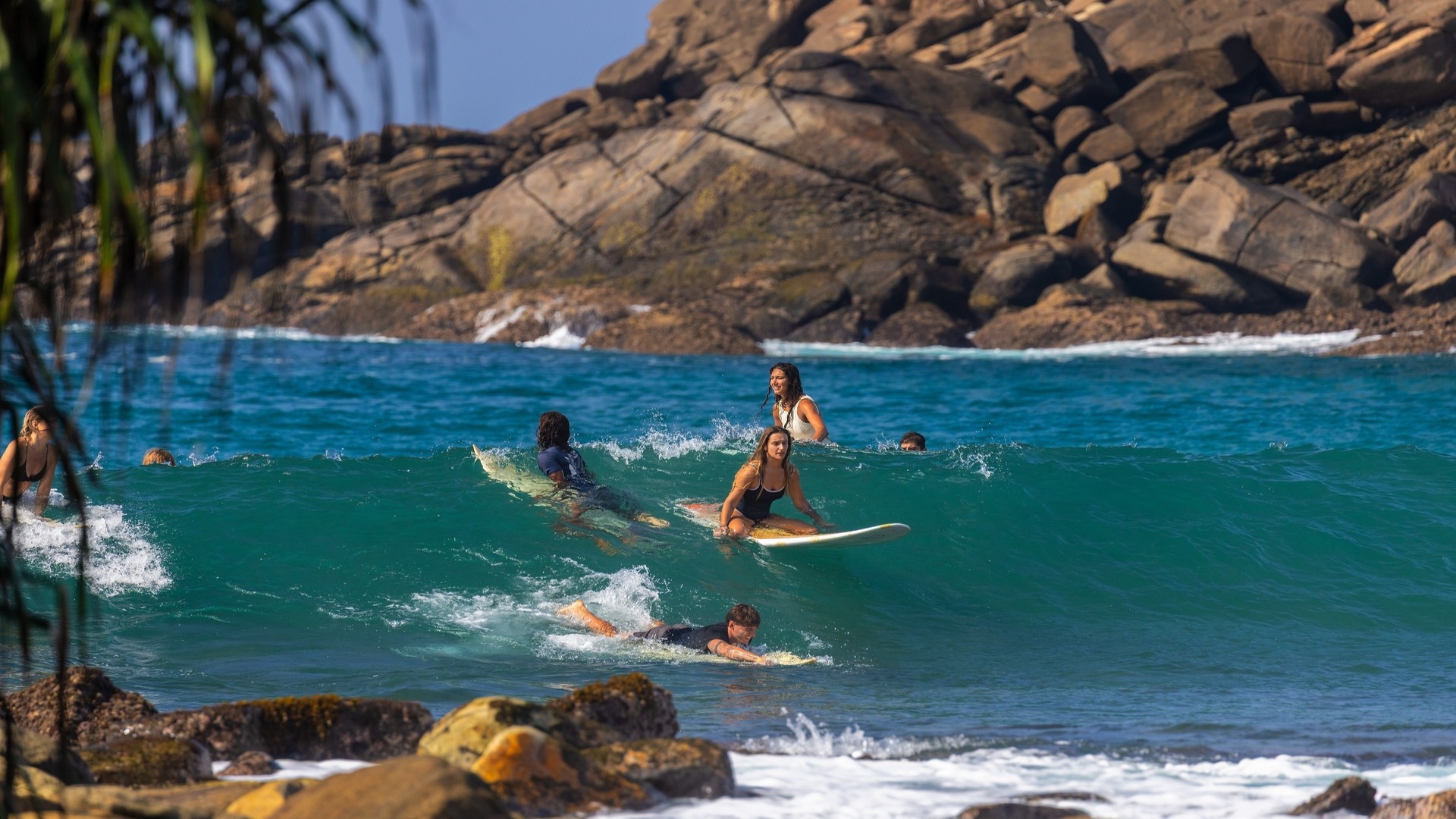 Серферы у скалистого тропического побережья в Хирикетии.