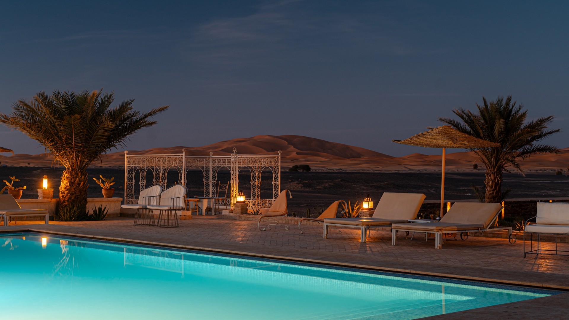 Роскошный отель в пустыне с бассейном с видом на песчаные дюны, Марокко.