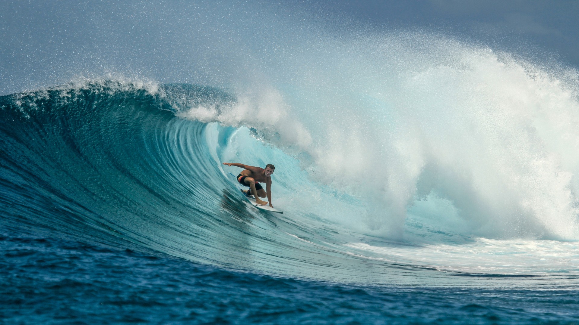 Серфер на идеальной голубой волне, остров Тулусду.